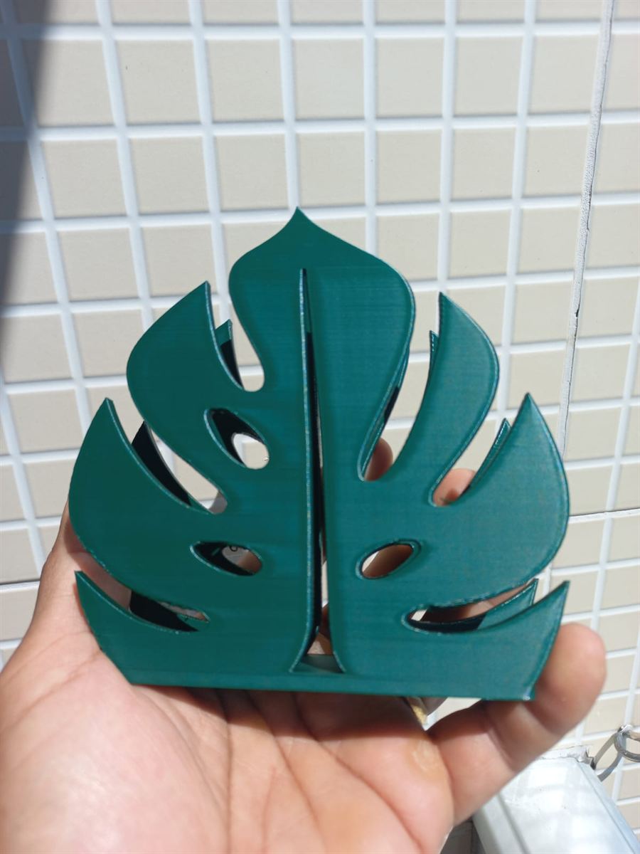 Porta-guardanapo verde em forma de folha de costela-de-adão na palma da mão